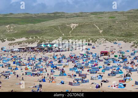 Il sole fa risuonare la folla sulla spiaggia di Perranporth, mentre le distanze sociali vengono dimenticate. Foto Stock