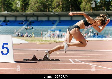 girl runner sprinter che corre dai blocchi di partenza alla concorrenza Foto Stock