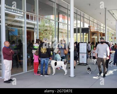 COVID-19 era mascherato e non mascherato pedoni, cani da passeggio, e in fila fuori una gelateria di sale e Straw al City Center Bishop Ranch a San Ramon, California, 24 aprile 2021. () Foto Stock