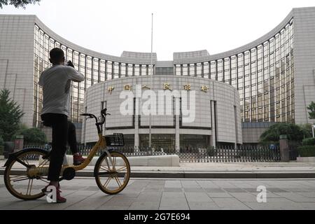 Un uomo in bicicletta usa il suo cellulare per scattare una foto della sede della Banca popolare Cinese. La banca centrale cinese taglierà il coefficiente di riserva obbligatoria (RRR) di 0.5 punti percentuali a partire da luglio 15, rilasciando circa 1 trilione di yuan (154 miliardi di dollari) in liquidità per sostenere l'economia. (Foto di Sheldon Cooper / SOPA Images/Sipa USA) Foto Stock