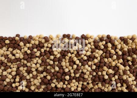cioccolato e vaniglia prima colazione a base di cereali, palle di cereali come sfondo, palle di mais al cioccolato in forma di cornice con ampio spazio per il testo, vista dall'alto Foto Stock