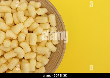 bastoncini di mais dolce in recipiente con ampio spazio per il testo isolato su sfondo giallo, vista dall'alto Foto Stock