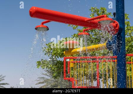 Tre spruzzi d'acqua rossi del parco spruzzano acqua sopra per il divertimento estivo dei bambini. Foto Stock