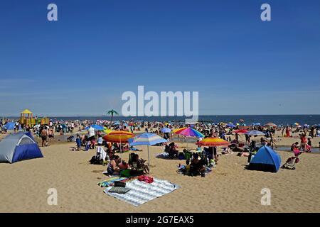 La gente alla spiaggia di Coney Island durante un caldo pomeriggio di domenica di Estate, a New York City. Foto Stock