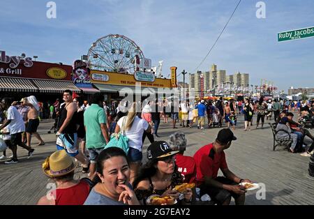 Persone sul lungomare di Coney Island, durante un caldo pomeriggio di domenica d'estate, a New York City. Foto Stock