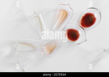 Piatto con bicchieri con vino diverso su sfondo bianco. Foto Stock