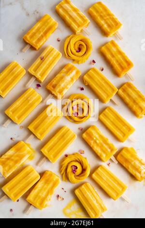 Mango Lassi Poppsciles su superficie di marmo Foto Stock