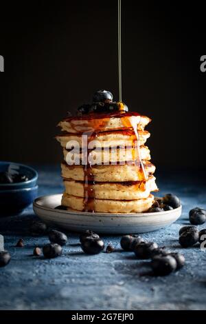 Frittelle al cioccolato con mirtilli, sciroppo d'acero e zucchero in polvere Foto Stock