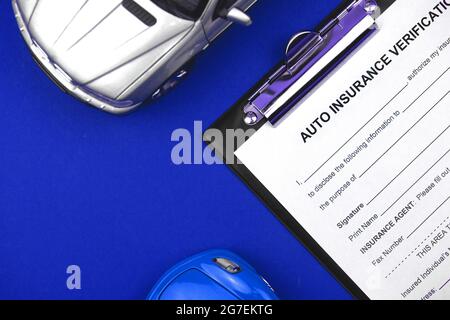 Modulo di richiesta assicurazione auto con giocattolo per auto sul tavolo e sul desktop dell'ufficio. Concetto di protezione dagli incidenti. Vista dall'alto Foto Stock