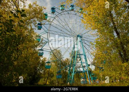 Ruota panoramica nella foresta autunnale. Vista panoramica dalla foresta alla ruota panoramica. Foto Stock