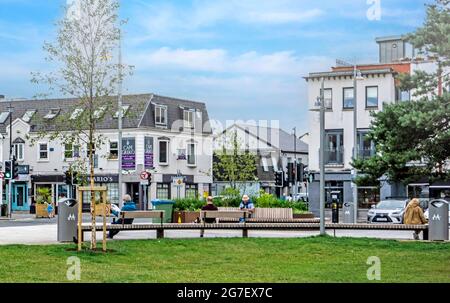 Persone che godono di bel tempo sul Green, Malahide, Dublino del Nord, Irlanda. Foto Stock