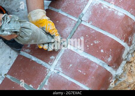 Riempire i giunti con un sacchetto di spremitura cremoso. Cementazione Foto Stock