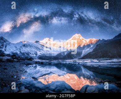 Milky Way su montagne innevate e lago di notte. Orizzontale Foto Stock