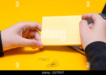 Donna mano tenere vuoto Note scrivere nuovo Messege aggiornamenti idee accanto al portatile. Lady Palm mostra inviluppo piegatura lettere di invio Indirizzo postale e. Foto Stock