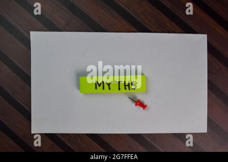 I miti scrivono su note appiccicose isolate su tavola di legno. Foto Stock
