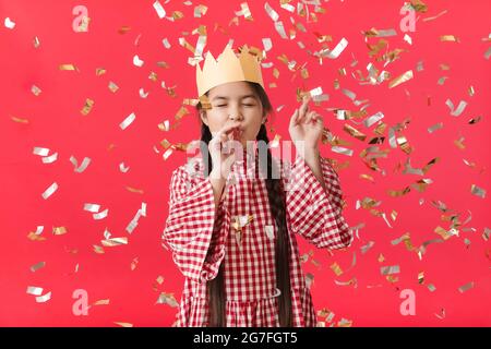 Carino bambina che celebra il compleanno su sfondo a colori Foto Stock