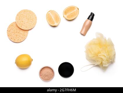 Spugne con prodotti cosmetici, loofah e limone su sfondo bianco Foto Stock
