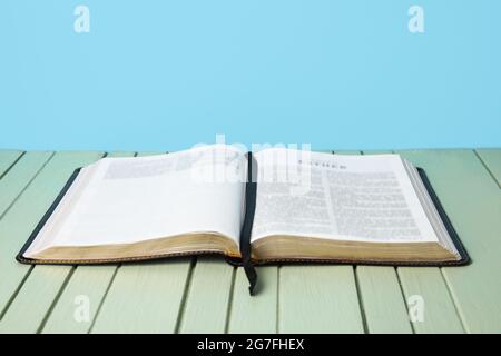 Apri la Bibbia Sacra su un tavolo di legno a colori Foto Stock