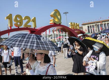 Pechino, Cina. 09 luglio 2021. I turisti camminano sotto l'emblema del Partito Comunista in Piazza Tiananmen di Pechino. Dopo l'incontro per celebrare il centesimo anniversario della fondazione del Partito Comunista Cinese, tenutosi il 1 luglio, Piazza Tiananmen conserva ancora paesaggi come il numero dell'anno dell'emblema del partito del Partito Comunista Cinese. I turisti sono desiderosi di visitare Piazza Tiananmen. Per soddisfare le esigenze delle masse, il paesaggio di Piazza Tiananmen è riservato fino al luglio 31. (Foto di Sheldon Cooper/SOPA Images/Sipa USA) Credit: Sipa USA/Alamy Live News Foto Stock