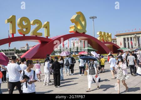 Pechino, Cina. 09 luglio 2021. I turisti camminano sotto l'emblema del Partito Comunista in Piazza Tiananmen di Pechino. Dopo l'incontro per celebrare il centesimo anniversario della fondazione del Partito Comunista Cinese, tenutosi il 1 luglio, Piazza Tiananmen conserva ancora paesaggi come il numero dell'anno dell'emblema del partito del Partito Comunista Cinese. I turisti sono desiderosi di visitare Piazza Tiananmen. Per soddisfare le esigenze delle masse, il paesaggio di Piazza Tiananmen è riservato fino al luglio 31. (Foto di Sheldon Cooper/SOPA Images/Sipa USA) Credit: Sipa USA/Alamy Live News Foto Stock