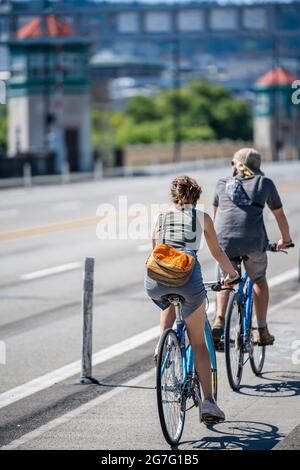 I ciclisti di uomo e donna fanno un viaggio in bicicletta viaggiando attraverso la città su un percorso ciclabile dedicato insieme, preferendo un vero e proprio stile di vita sano e attivo Foto Stock