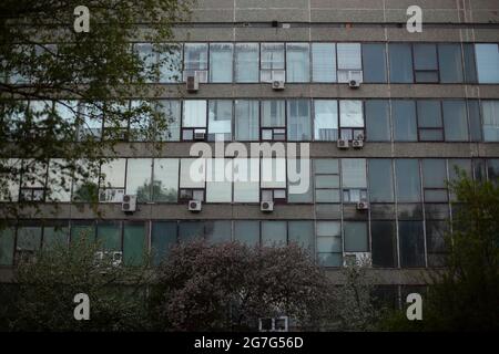 Facciata di un edificio di uffici climatizzato. Edificio industriale in serata. Edificio lungo con aria condizionata. Foto Stock