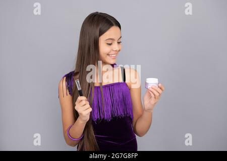 Happy Kid tenere trucco pennello e viso polvere grigio sfondo, visage Foto Stock