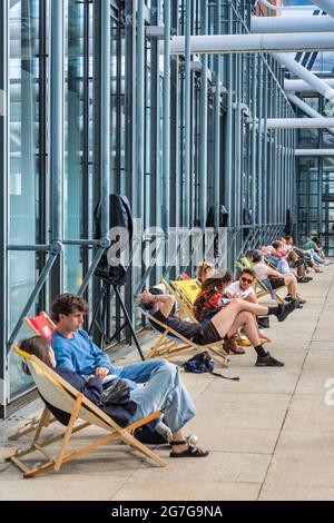 Persone che si rilassano in sedie a sdraio al piano superiore della galleria d'arte Centre Pompidou - Parigi, Francia. Foto Stock