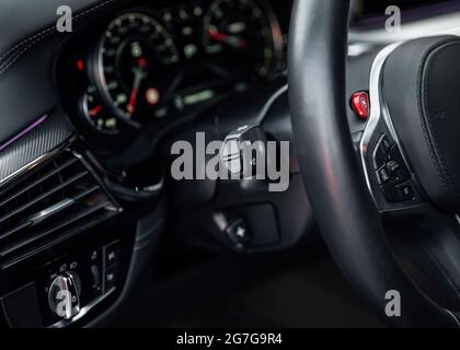 Interni moderni per auto sportive, concetto di viaggio. Cruscotto per auto. Mettere a fuoco la manopola del faro nella vettura. Foto Stock