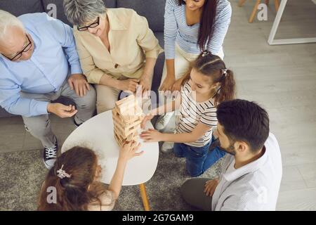 La grande famiglia gioca il gioco da tavolo Jenga. Foto Stock