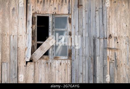 Finestra rotta di una casa di legno abbandonata Foto Stock