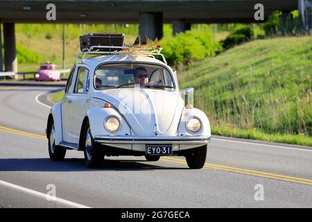 Volkswagen Beetle biancastro, ufficialmente Volkswagen tipo 1, a velocità con bagaglio e due paia di sci sul portapacchi. Salo, Finlandia. 18 maggio 2019. Foto Stock