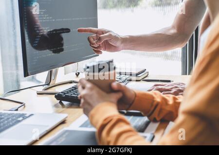 I programmatori che collaborano allo sviluppo della programmazione e del sito web che lavorano in un ufficio di sviluppo di software aziendale, scrivendo codici e digitando codice di dati, Progra Foto Stock