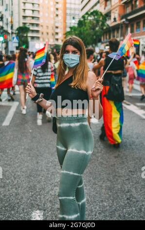VALENCIA, SPAGNA - Giu 28, 2021: Ritratto di verticale Foto di Blonde Trans Girl con Rainbow LGTB piccole bandiere a Gay Pride dimostrazione. Foto Stock