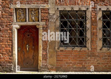 Vecchia porta in legno ornata con batticalcagno e finestre sbarrate in una casa a Boettcherstrasse nel centro storico di Brema, Germania, Brema Foto Stock