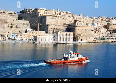 Pilota barca nel porto, capitale Valetta sullo sfondo, Malta, Valetta Foto Stock