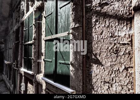 Facciata di capanna ricoperta di corteccia di legno in Svizzera sassone con persiane chiuse di colore verde scuro e ombre profonde Foto Stock