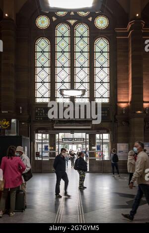 I viaggiatori camminano attraverso la vecchia sala principale della stazione ferroviaria SNCF di Strasburgo, Francia. Foto Stock