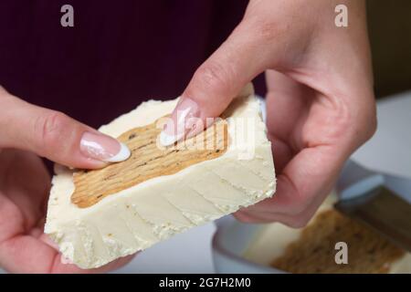 Donna taglia gelato fatto in casa. Biscotti e crema. Primo piano. Foto Stock