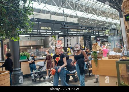 Londra - Luglio 2021: Bancarelle di cibo all'interno del mercato di Spitalfields. Un mercato popolare con cibo, bar, arte e artigianato Foto Stock