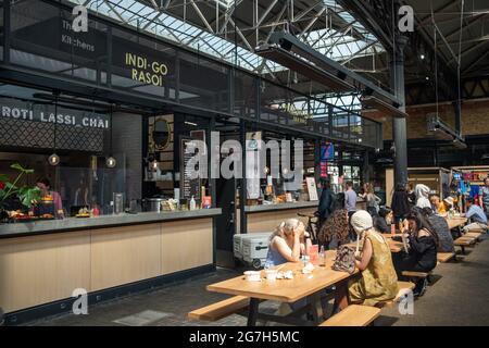 Londra - Luglio 2021: Bancarelle di cibo all'interno del mercato di Spitalfields. Un mercato popolare con cibo, bar, arte e artigianato Foto Stock