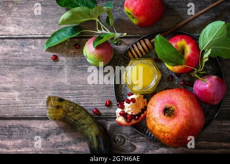 Immagine religiosa del concetto di Rosh hashanah (festa ebraica di Capodanno). Simboli tradizionali: Miele, mele e melograno su un tavolo rustico scuro. Vista dall'alto Foto Stock