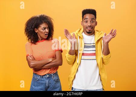 Jeez uomo che il vostro problema. Offeso dispiaciuto afroamericano elegante e attraente ragazza che guarda il ragazzo comportandosi cool fingendo lui Foto Stock