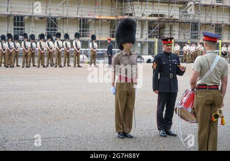 Wellington Barracks, Londra, Regno Unito. 14 luglio 2021. Grenadier Guards, che si sfila sul campo della parata a Wellington Barracks in una giornata calda. In primo piano un sergente-maggiore della società, ufficiale di garanzia di classe 2 in blu n° 1 vestito con il badge full size di rango sul braccio destro, a sua destra un capitano in n ° 13 Barrack abito, camicia ordine manica. Credit: Malcolm Park/Alamy Live News. Foto Stock