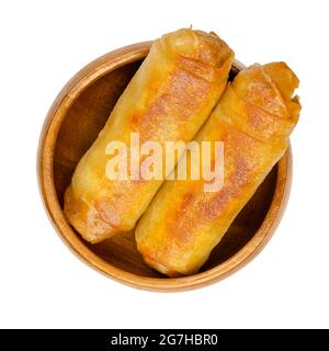 Involtini di primavera fritti, in un recipiente di legno. Due involtini primaverili, fritti croccanti in una padella. Involtini ripieni e arrotolati, antipasti di cucina asiatica. Foto Stock