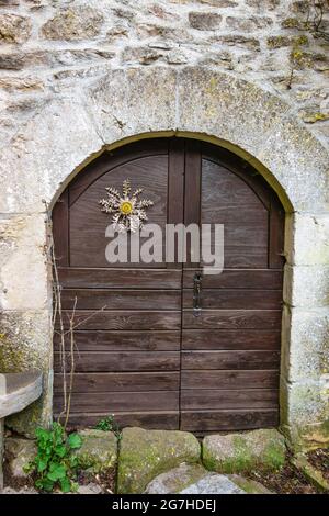 Carlina su porta di legno, la Couvertoirade, Aveyron, Francia // Chardon sur porte en bois, la Couvertoirade, Causses, Aveyron (12), Francia Foto Stock