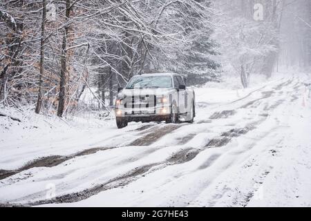 Camion negozia fangoso, strada sterrata nevosa durante la stagione di fango a Montpelier, Vermont, New England, USA. Foto Stock