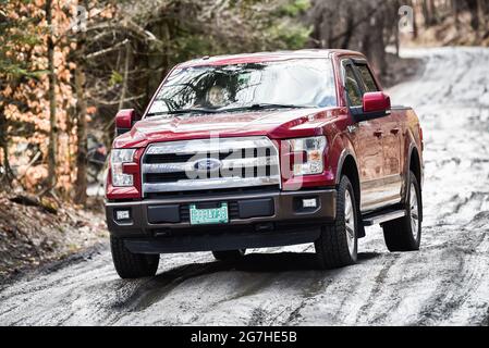 Camion negozia fangoso, strada sterrata nevosa durante la stagione di fango a Montpelier, Vermont, New England, USA. Foto Stock