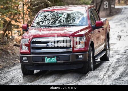 Camion negozia fangoso, strada sterrata nevosa durante la stagione di fango a Montpelier, Vermont, New England, USA. Foto Stock