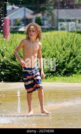 Un ragazzo (9 anni) che gioca in giochi d'acqua e fontane a Quebec City, Canada Foto Stock